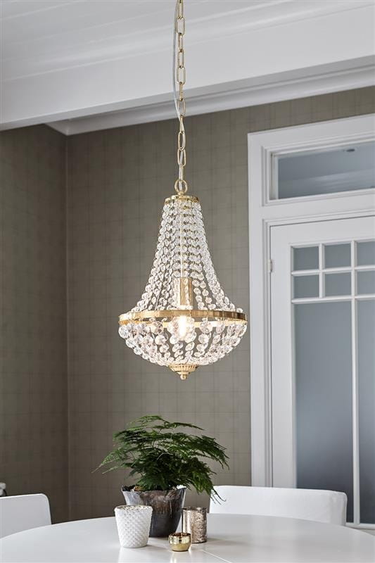 Lampa wisząca Granso 1-punktowa w kolorze złotym, z przezroczystymi kryształkami, zawieszona na złotym łańcuchu. Oświetlenie w stylu klasycznym, idealne do jadalni, z widoczną żarówką w centralnej części. Tło w neutralnym kolorze.