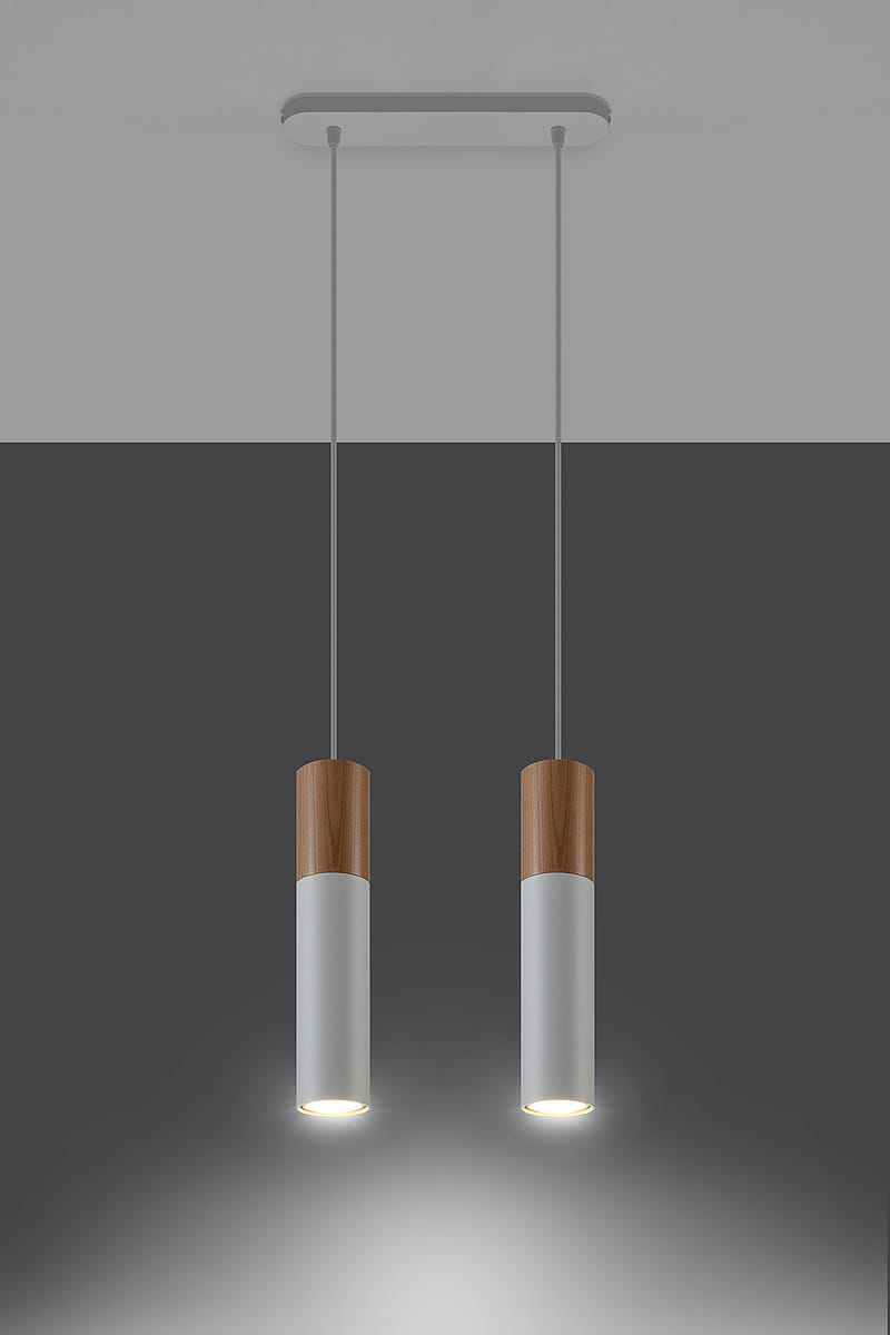 Lampa wisząca Pablo 2-punktowa w kolorze białym z drewnianymi elementami. Posiada dwa cylindryczne klosze o matowej powierzchni, zawieszone na cienkich linkach. Montowana do sufitu, z widocznym oświetleniem na dole kloszy. Tło w odcieniach szarości.