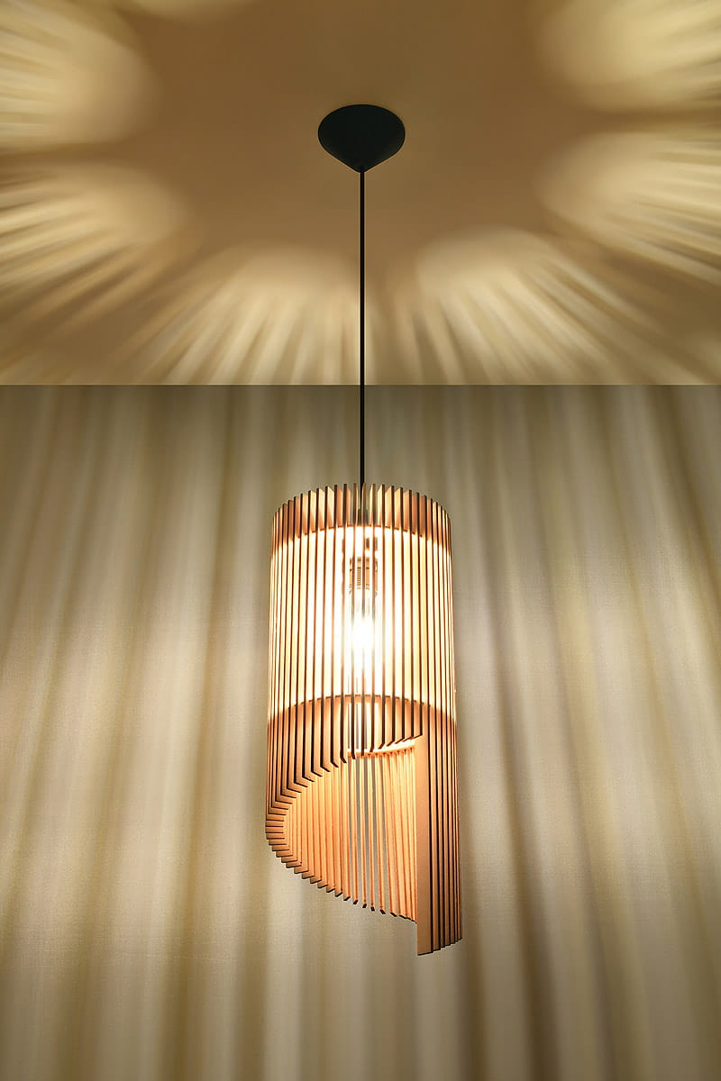 Lampa wisząca Alexia 1-punktowa SL.0640 w kształcie cylindrycznym, wykonana z drewna w odcieniu jasnobrązowym. Widoczny detal: szczeliny w konstrukcji, które tworzą efekt świetlny.