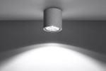 Lampa sufitowa Cullo 1-punktowa w kolorze szarym z betonu, zamontowana na suficie, z okrągłym kloszem odsłaniającym źródło światła. Oświetlenie skierowane w dół tworzy subtelne cienie na ścianie. Prosty, minimalistyczny design.