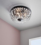 Czarna lampa sufitowa 3-punktowa Vasa z kryształowymi detalami. Okrągła konstrukcja z przezroczystymi, błyszczącymi elementami odbijającymi światło, zamontowana na suficie. Widoczny czarny mocownik w centralnej części.