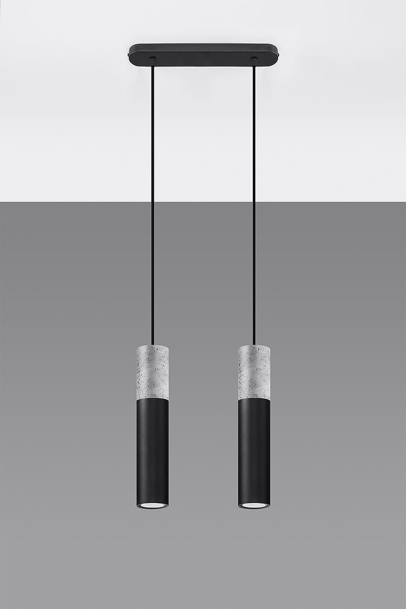 Lampa wisząca Borgio 2-punktowa, czarna, z dwoma cylindrycznymi kloszami. Klosze mają górną część z betonu i dolną z matowego czarnego metalu. Produkt zawieszony na czarnych linkach, zamontowany na prostokątnej podstawie. Tło w odcieniach szarości.