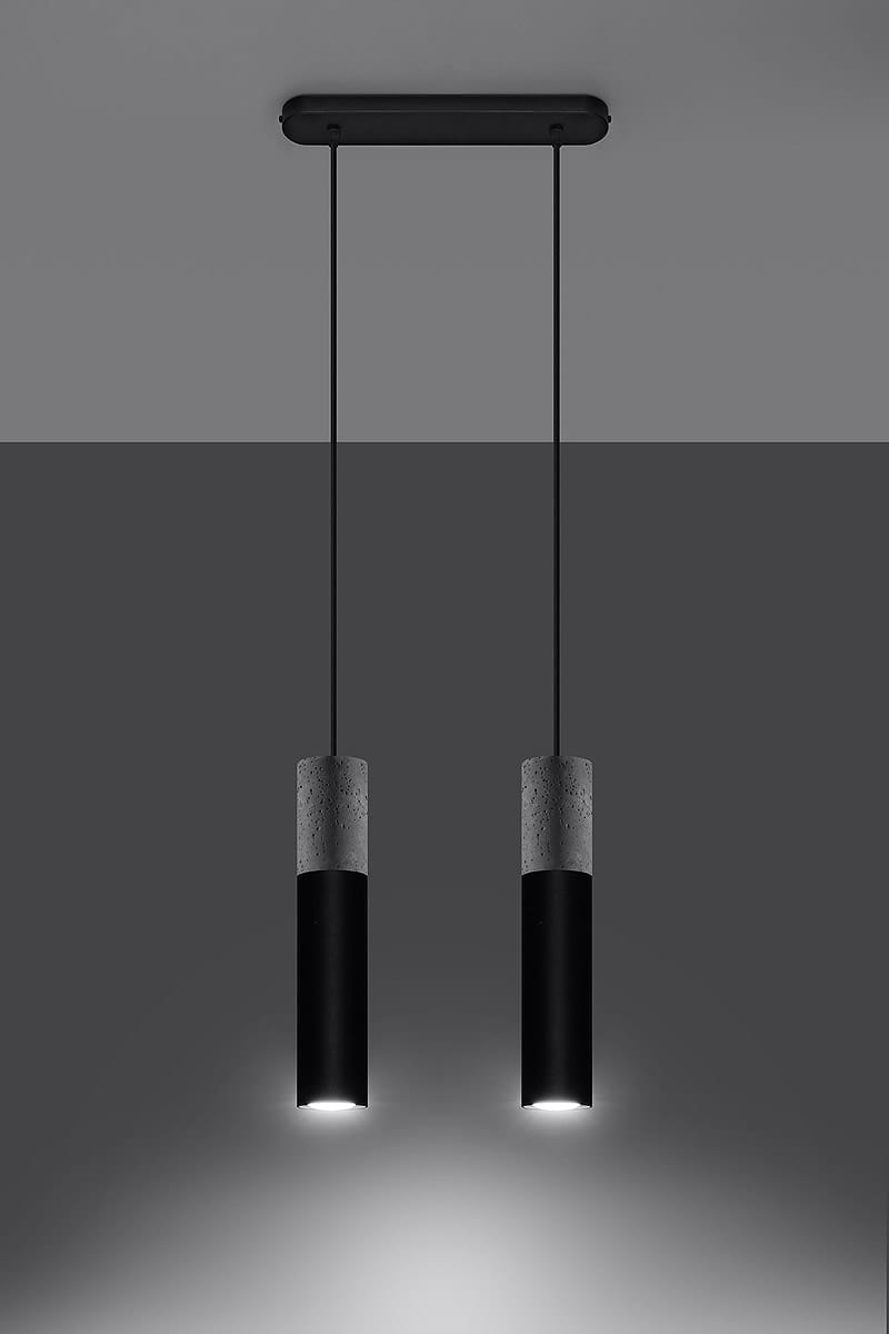 Czarna lampa wisząca Borgio, 2-punktowa, z betonowymi elementami, zawieszona na cienkich czarnych przewodach. Lampa ma cylindryczny kształt z matowym wykończeniem, oświetlająca przestrzeń dolnym światłem. Ujęcie frontalne na tle szaro-skalnym.