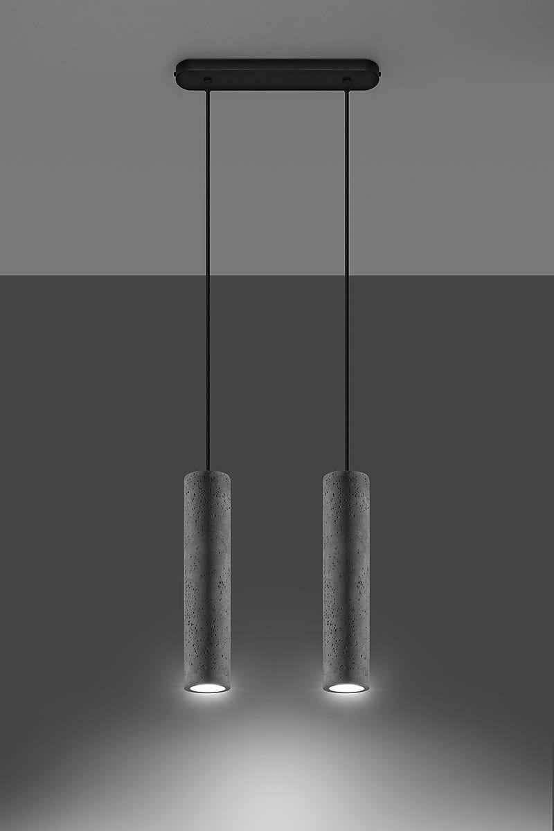 Lampa wisząca Luvo, 2-punktowa, z betonu, składająca się z dwóch cylindrycznych kloszy w kolorze szarym na czarnych przewodach, zawieszona na prostokątnej podstawie. Produkt wisi w poziomie, na jednolitym tle szarym.