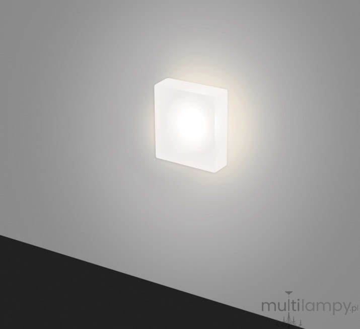 Oprawa schodowa Lesel LED 008 XL w kształcie prostokąta, wykonana z białego materiału, zamontowana na ścianie. Emituje ciepłe światło, tworząc delikatny blask. Tło w odcieniu szaro-beżowym, podłoga ciemna.