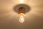 Lampa sufitowa Salgado Drewno 1-punktowa SL.0672 z drewnianym kloszem w naturalnym kolorze. Żarówka w kształcie kropli, zawieszona na metalowym mocowaniu. Światło rozpraszane, tworzy miękkie cienie na suficie. Ujęcie z dołu.