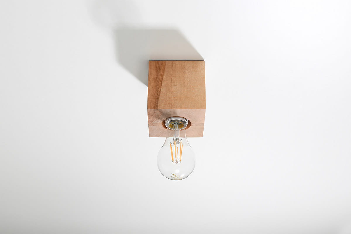 Lampa sufitowa Ariz Drewno 1-punktowa SL.0675 z kwadratowym, jasnobrązowym drewnianym kloszem. Widoczna przezroczysta żarówka z widocznymi włóknami. Produkt zamontowany na suficie, z prostym, białym tłem.