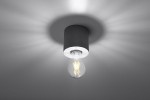 Lampa sufitowa Salgado Beton z szarym, cylindrycznym kloszem z betonu, zawieszona na suficie. Widoczna żarówka w przezroczystym kloszu, emitująca miękkie światło. Ujęcie z dołu, ukazujące detale lampy i cienie na suficie.