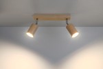 Lampa sufitowa Berg 2-punktowa SL.0702 z drewnianymi kloszami w kolorze naturalnym, zamontowana na prostokątnej bazie z drewna. Klosze skierowane są w różnych kierunkach, oświetlając ścianę. Metalowe elementy wykończenia w srebrnym kolorze.