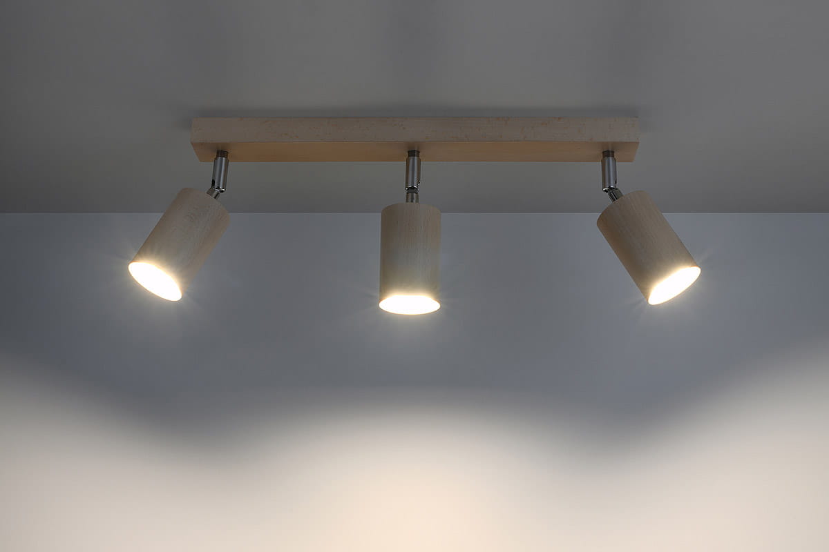 Lampa sufitowa Berg 3-punktowa SL.0703 w kolorze naturalnego drewna z trzema cylindrycznymi kloszami. Ujęcie z góry, zamontowana na ścianie, emitująca jasne światło. Prosta, minimalistyczna konstrukcja.