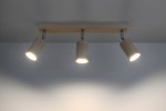 Lampa sufitowa Berg 3-punktowa SL.0703 w kolorze naturalnego drewna z trzema cylindrycznymi kloszami. Ujęcie z góry, zamontowana na ścianie, emitująca jasne światło. Prosta, minimalistyczna konstrukcja.