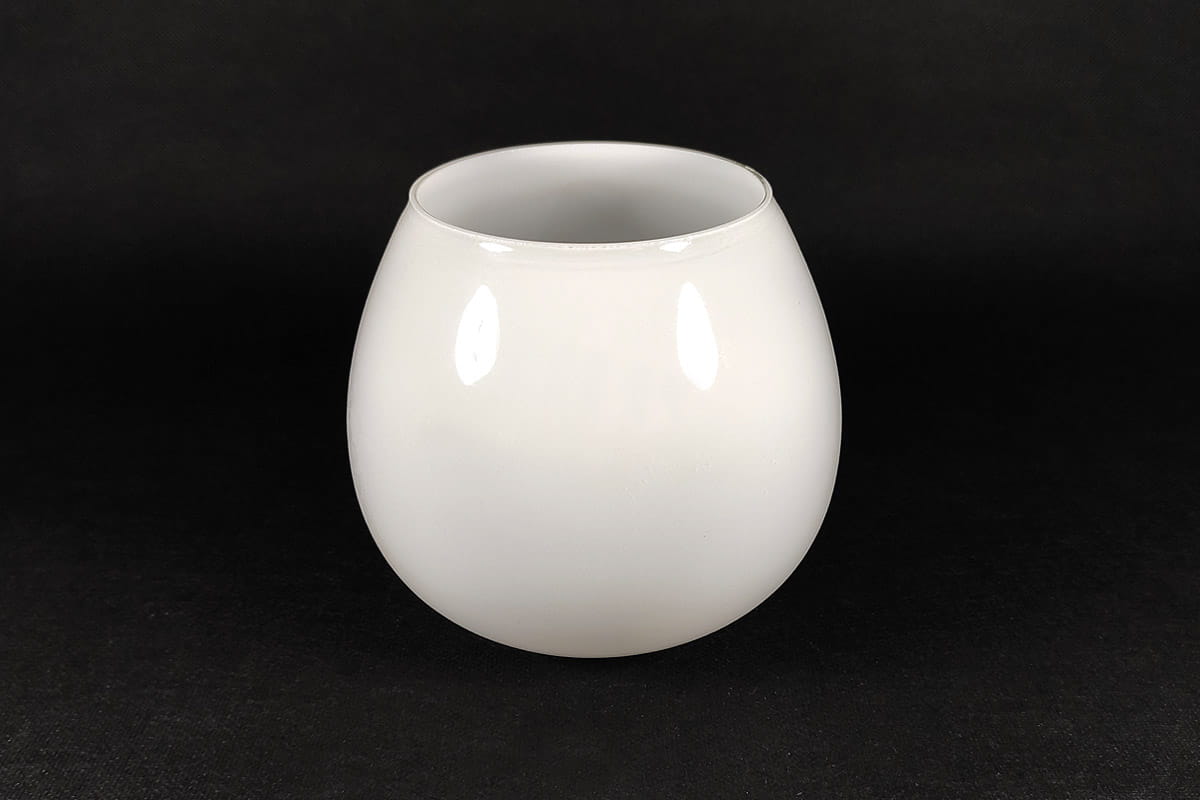 Klosz szklany Moza D130 w kolorze białym z połyskiem, o zaokrąglonym kształcie. Ujęcie frontalne, produkt stoi na czarnym tle. Wnętrze klosza jest gładkie, bez zdobień. Idealny do lamp.