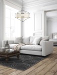 Lampa wisząca Stesso Cromo M w kolorze chromu z czterema punktami świetlnymi, z okrągłym, białym kloszem. Zawieszona w jasnym wnętrzu nad białą sofą i drewnianym stolikiem. Tło z dużymi oknami i jasnymi ścianami.