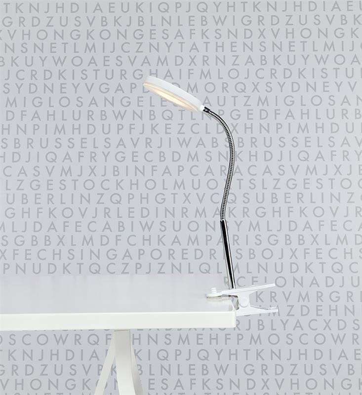 Flex Klip LED kinkiet 1-punktowy w kolorze białym i chromowanym, z elastycznym ramieniem, zamocowany na białym stole. Lampa ma nowoczesny, minimalistyczny design, idealna do biura lub czytania, z jasnym źródłem światła skierowanym w górę.