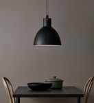 Czarna lampa wisząca Eagle D35 z metalowym kloszem w kształcie stożka, zawieszona nad drewnianym stołem. Widoczny element mocujący w kolorze brązowym. Tło w odcieniu szaro-beżowym, z dodatkowymi akcesoriami kuchennymi na stole.