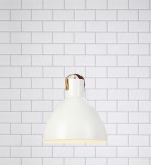 Biała lampa wisząca Eagle D35 z metalowym kloszem w kształcie stożka, zawieszona na białym przewodzie. Posiada skórzany uchwyt mocujący. Tło w formie białej cegły podkreśla nowoczesny design.