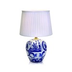 Lampka stołowa Goteborg D48 z niebieską i białą ceramiczną podstawą w kształcie kuli, ozdobioną wzorami ptaków i kwiatów. Posiada plisowany, biały klosz z materiału, zamontowany na złotym talerzyku, ustawiona frontalnie na gładkiej powierzchni.