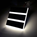 Vox LED oprawa schodowa 230V w formie kwadratowej, z trzema poziomymi paskami emitującymi zimne światło o temperaturze 6500K. Produkt z widocznym przewodem, z matową czarną obudową.