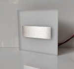 Lumi LED oprawa schodowa 230V z matowym, białym tłem oraz metalowym, szczotkowanym akcentem. Produkt umieszczony w pozycji stojącej, z widocznymi przewodami. Barwa światła zimna 6500K, idealna do oświetlenia schodów.