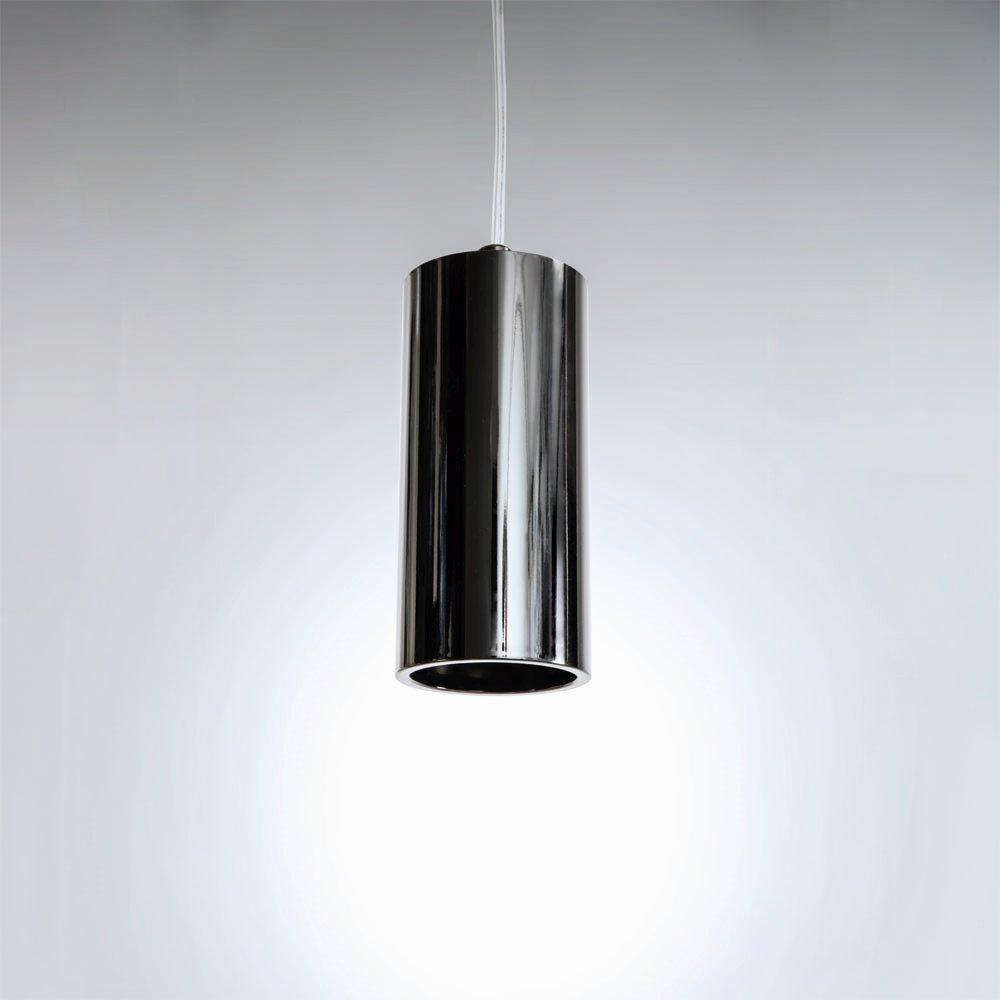 Lampa wisząca Kika S 120 w kształcie cylindrycznym, wykonana z błyszczącego, metalicznego materiału. Zawieszona na przezroczystym przewodzie, emitująca światło z otworu na dole. Tło jasne, minimalistyczne.
