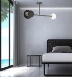 Lampa sufitowa Minerva 2-punktowa w kolorze czarnym, z okrągłymi, matowymi kloszami oraz złotymi detalami. Zawieszona w pokoju, w nowoczesnym wnętrzu z łóżkiem i stolikiem nocnym. Kąt ujęcia z boku, ukazujący subtelne połączenie kolorów i stylu.