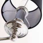 Kinkiet Abu Dhabi 1-punktowy w kolorze chromu i czerni, z metalowym uchwytem i czarnym kloszem. Ujęcie z bliska, ukazujące błyszczące elementy oraz detal wykończenia. Klosz ma okrągły kształt i jest lekko otwarty od góry.