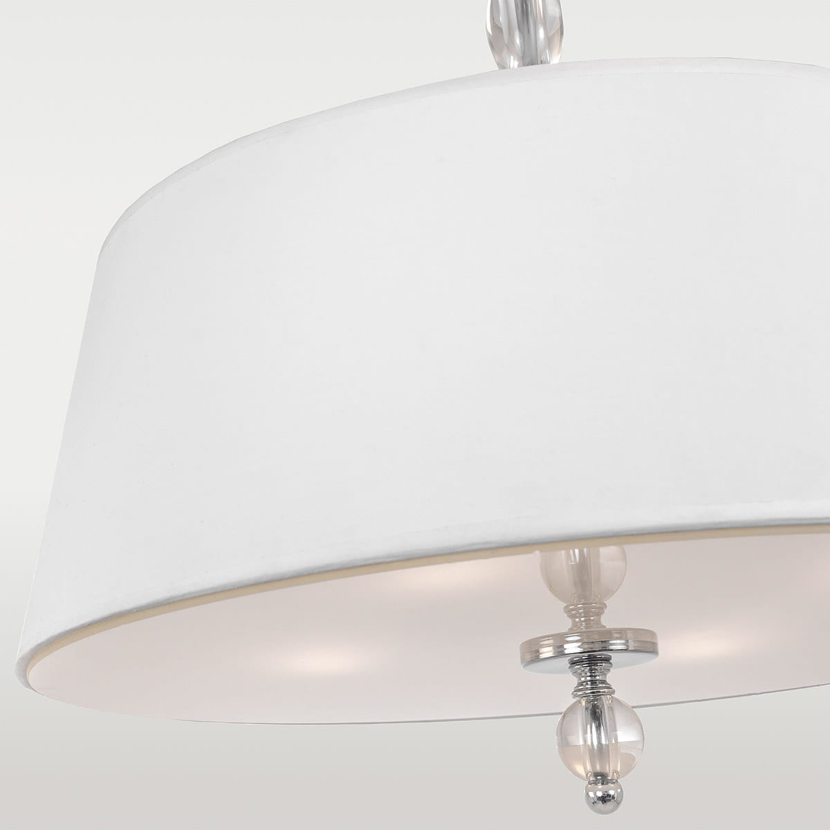 Lampa wisząca Cancun 4-punktowa, biała, z okrągłym kloszem z tkaniny. Widoczny chromowany element z przezroczystą kulką na dole. Ujęcie z dołu, pokazujące detale klosza oraz dekoracyjne wykończenie.