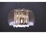 Lampa wisząca Burn 2, 6-punktowa, w chromowanej obudowie z przezroczystymi elementami. Kształt okrągły, z dekoracyjnymi kulkami i żarówkami wewnątrz. Zawieszona na cienkich linkach, w tle ciemna ściana.