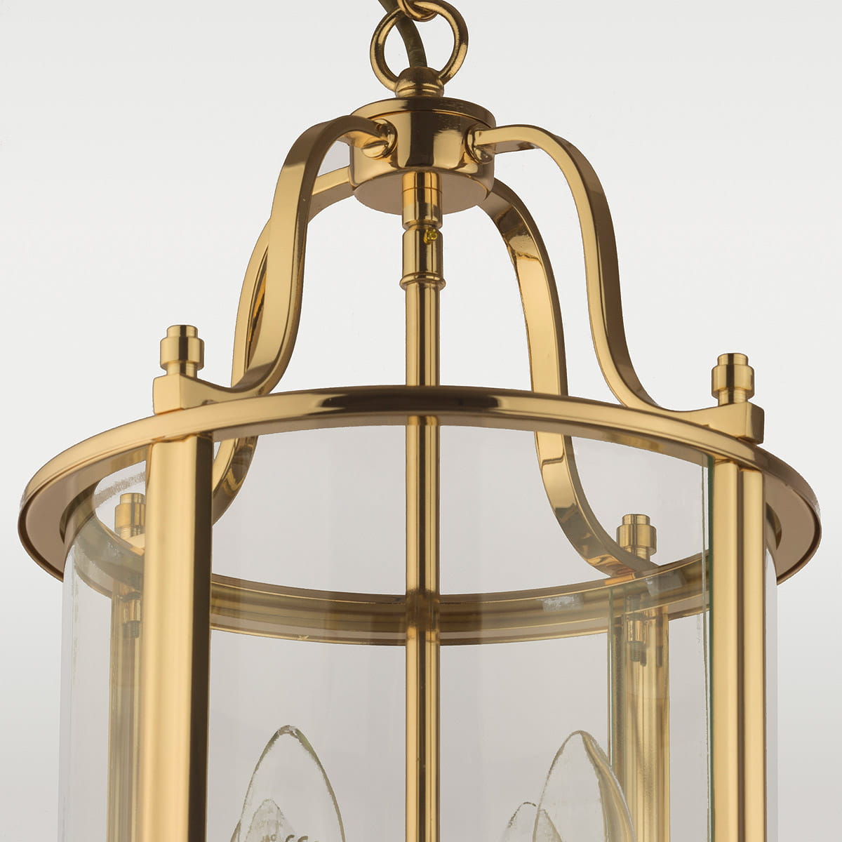 Złota lampa wisząca New York z czterema punktami świetlnymi, wykonana z metalu i szkła. Okrągła podstawa z gładką, błyszczącą powierzchnią oraz przezroczysty klosz, ukazujący wewnętrzne źródła światła. Montowana na łańcuchu, w ujęciu z góry.