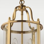 Złota lampa wisząca New York z czterema punktami świetlnymi, wykonana z metalu i szkła. Okrągła podstawa z gładką, błyszczącą powierzchnią oraz przezroczysty klosz, ukazujący wewnętrzne źródła światła. Montowana na łańcuchu, w ujęciu z góry.