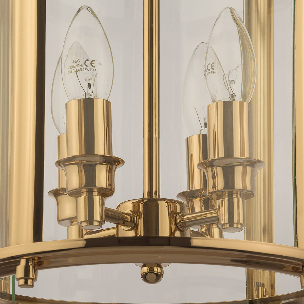 Złota lampa wisząca New York z 4 punktami świetlnymi, z metalowymi detalami. Widok z bliska na uchwyty żarówek i przezroczyste klosze. Lampa ma okrągłą podstawę i elegancki, nowoczesny design, idealna do stylowych wnętrz.
