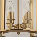 Złota lampa wisząca New York z 4 punktami świetlnymi, z metalowymi detalami. Widok z bliska na uchwyty żarówek i przezroczyste klosze. Lampa ma okrągłą podstawę i elegancki, nowoczesny design, idealna do stylowych wnętrz.