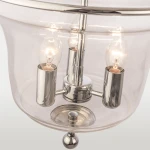 Lampa wisząca Prague 3-punktowa, z przezroczystym kloszem i metalowymi elementami w kolorze chromu. Widoczne trzy żarówki w cylindrycznych oprawach. Produkt zamontowany na stalowej podstawie z dekoracyjną kulką.