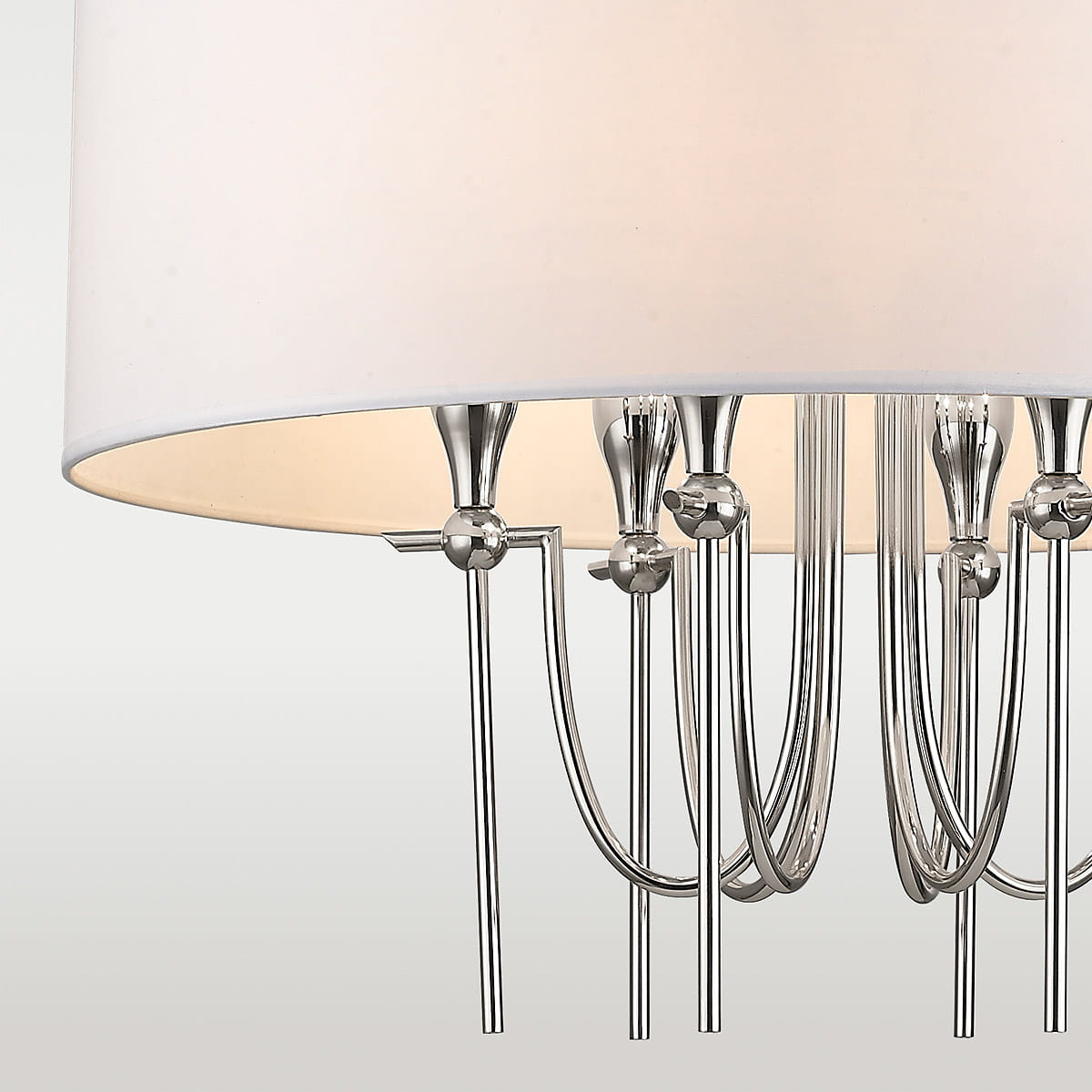 Lampa wisząca Las Vegas 6-punktowa w kolorze niklu. Posiada sześć metalowych ramion z kulistymi zdobieniami, zakończonych źródłami światła. Klosz w jasnym kolorze, o okrągłym kształcie. Widok z dołu, ukazujący detale konstrukcji.
