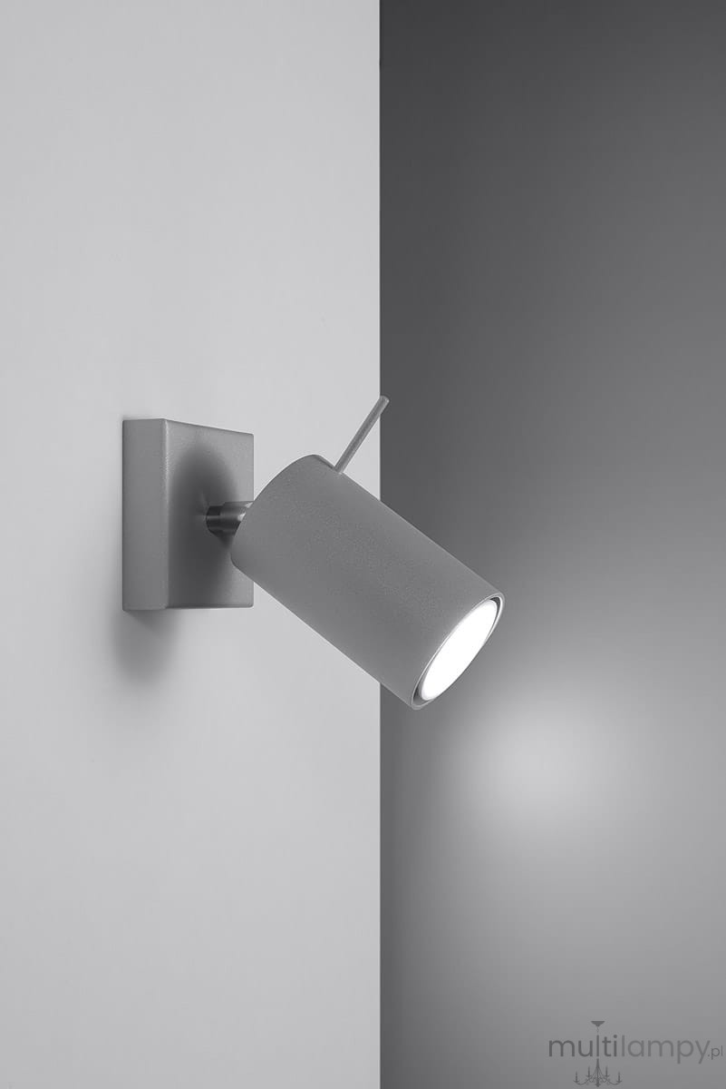 Kinkiet Ring 1-punktowy w kolorze szarym, z okrągłą oprawą montowaną na kwadratowej podstawie. Lampa jest skierowana w dół, emitując światło. Materiał ma matową teksturę, a konstrukcja jest minimalistyczna, idealna do nowoczesnych wnętrz.