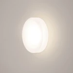 Oprawa schodowa Lesel LED 009 L w formie okrągłej, biała, z miękkim światłem emitowanym z centralnej części. Zainstalowana na gładkiej, jasnej ścianie, idealna do oświetlenia schodów lub korytarzy.