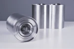 Lampa sufitowa Bross 2-punktowa w kolorze aluminium, o okrągłym kształcie. Widoczne reflektory z przezroczystymi kloszami w centralnej części. Ujęcie z boku, na jednolitym tle, produkt leży na płaskiej powierzchni.