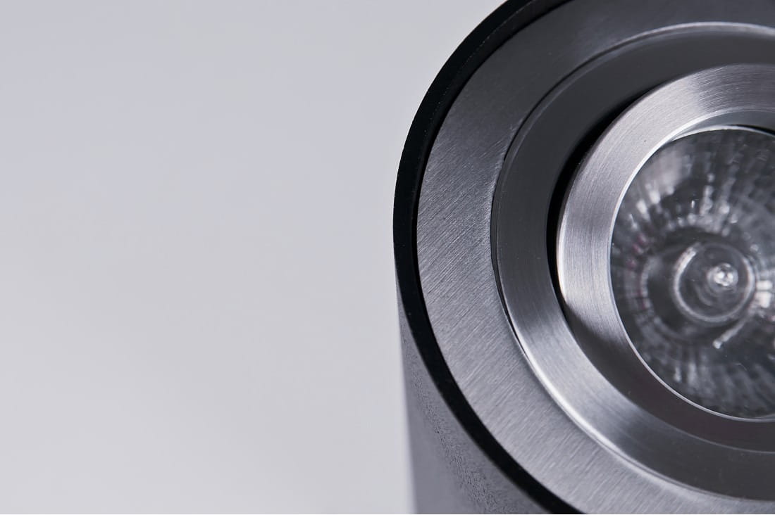 Lampa sufitowa Bross 2-punktowa w kolorze czarnym z aluminiowymi elementami. Widok z góry, ukazujący okrągłą, metalową oprawę z reflektorem w środku. Gładka, matowa powierzchnia z wykończeniem w srebrnym kolorze.