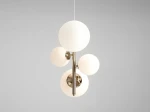 Lampa wisząca Bloom 4-punktowa w kolorze złotym, z okrągłymi kloszami w białym matowym szkle. Produkt zawiera cztery źródła światła, osadzone na metalowej konstrukcji. Wisi na cienkim przewodzie, na jednolitym tle.