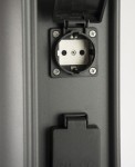 Lampa stojąca ogrodowa Elborn EL3113 z wbudowanymi gniazdami. Widok z bliska na gniazdo elektryczne, w kolorze czarnym, z zamkniętą pokrywą ochronną. Gniazdo z oznaczeniem IP44, przeznaczone do użytku zewnętrznego.