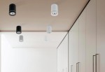 Biała lampa sufitowa LED Bill 1-punktowa, cylindryczna, z widoczną oprawą na sufit. Zawieszona na jasnym tle, w towarzystwie czarnych lamp. Prosty design, idealna do nowoczesnych wnętrz.