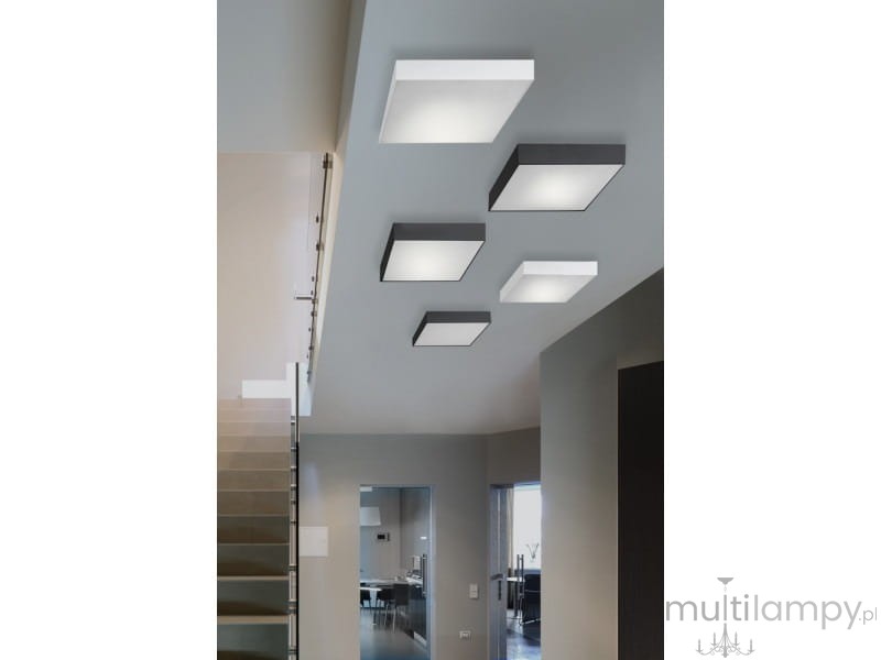 Plafon LED Monza S 22 4000K w kolorze białym, montowany na suficie. Prosty, kwadratowy kształt, z matowym wykończeniem. W tle widoczne inne plafony w ciemniejszych odcieniach. Oświetlenie w nowoczesnym wnętrzu.