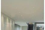 Czarna oprawa sufitowa Fill S LED 4000K do zabudowy, prostokątna, z zamontowanym źródłem światła. Widoczna w nowoczesnym wnętrzu na jasnym tle, z innymi punktami świetlnymi. Ujęcie z dołu, ukazujące równą linię montażu.