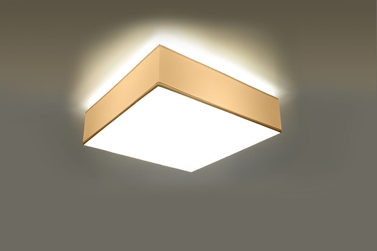 Lampa sufitowa Horus 25 w kolorze białym, o prostokątnej formie z lekko zaokrąglonymi krawędziami, zamontowana na suficie. Emituje miękkie światło, idealna do nowoczesnych wnętrz. Tło proste, szare, podkreślające design lampy.