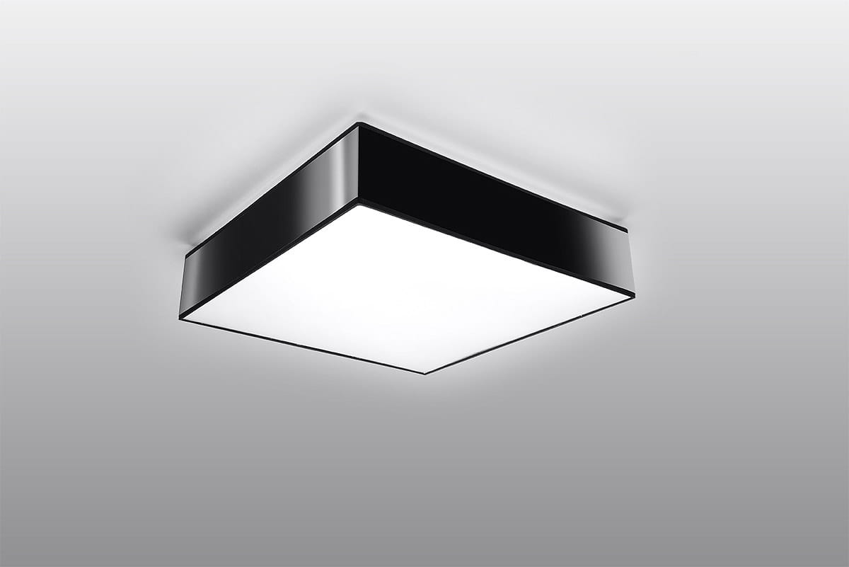 Lampa sufitowa Horus 25, 1-punktowa w kolorze czarnym, o kwadratowym kształcie. Ujęcie z dołu, pokazujące gładką, matową powierzchnię oraz jasną, emitującą światło część. Idealna do nowoczesnych wnętrz, zamontowana na prostym tle.
