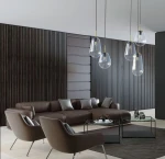 Lampa wisząca Pear L 1-punktowa, wykonana z przezroczystego szkła w kształcie gruszki, zawieszona na cienkim, czarnym przewodzie. Metalowe detale w złotym kolorze. Umiejscowiona w nowoczesnym wnętrzu z brązową sofą i szklanym stolikiem.