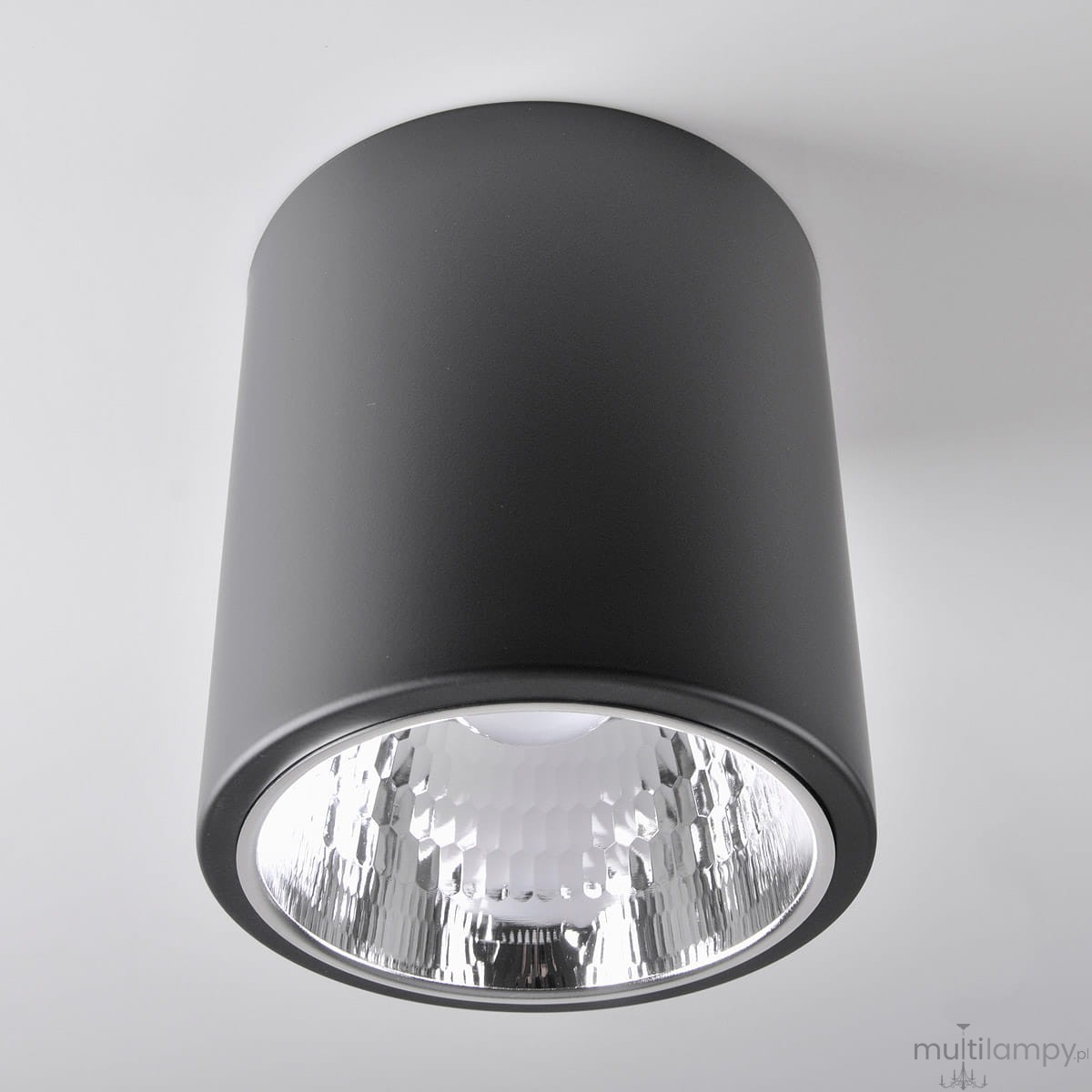 Lampa sufitowa natynkowa Jupiter 17 w czarnym kolorze, w formie tuby, z oprawą na żarówkę E27. Widoczny reflektor z teksturą w kształcie plastra miodu, montowana na suficie, zbliżenie na detal.