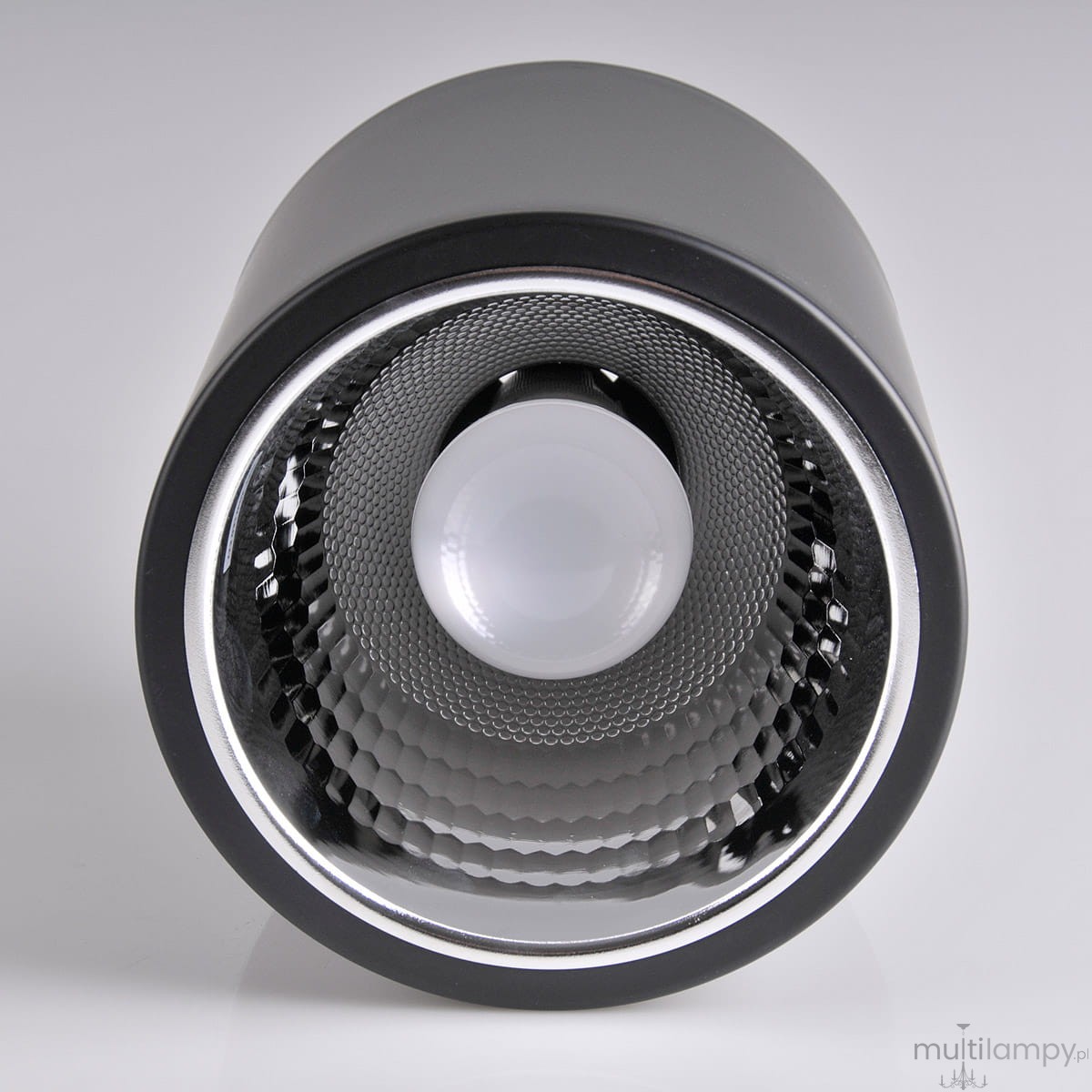 Lampa sufitowa natynkowa Jupiter 17 w kolorze czarnym, o cylindrycznym kształcie, z oprawą na żarówkę E27. Widoczna struktura wewnętrzna z siateczką reflektora oraz gładka zewnętrzna powierzchnia. Ujęcie frontalne.
