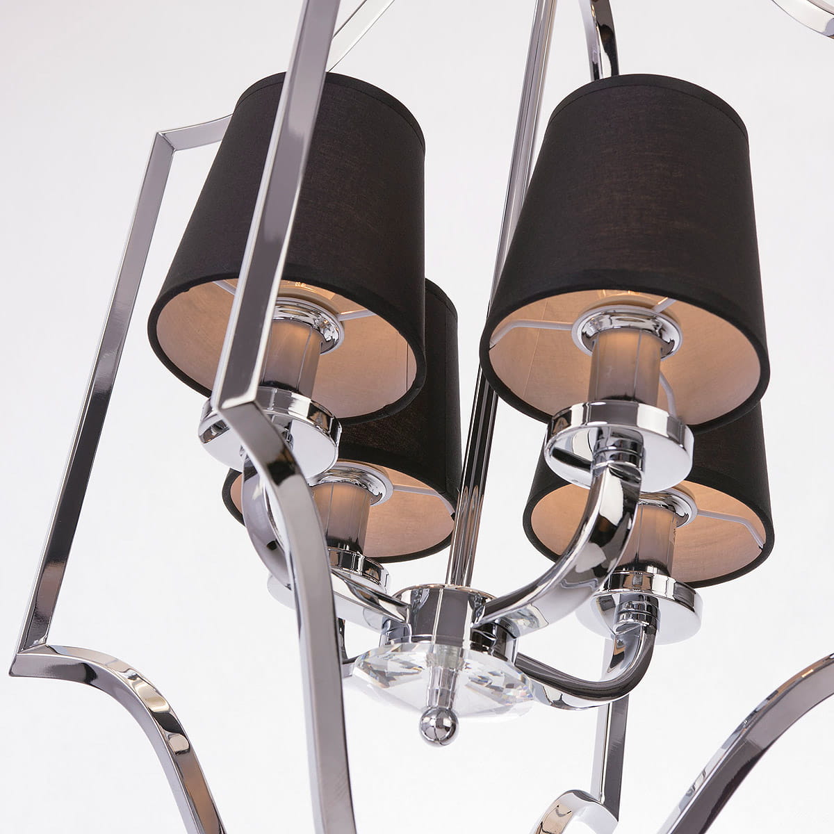 Lampa wisząca New York 4-punktowa, z czterema cylindrycznymi kloszami w czarnym materiale, metalową podstawą w kolorze chromu i dekoracyjnymi detalami. Ujęcie z góry, ukazujące połączenia i struktury lampy.