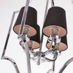 Lampa wisząca New York 4-punktowa, z czterema cylindrycznymi kloszami w czarnym materiale, metalową podstawą w kolorze chromu i dekoracyjnymi detalami. Ujęcie z góry, ukazujące połączenia i struktury lampy.